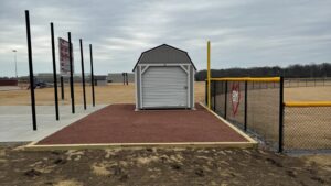 The integrated batting cage setup, complete with concrete pad, shed, and surrounding access.