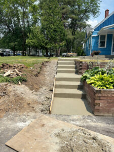 A set of new concrete steps under construction, with wooden forms in place, leading up to a home in Brookfield, WI.