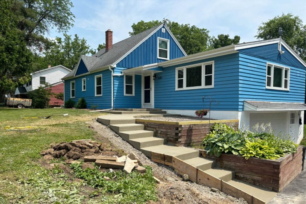 A wide view of the finished concrete steps and surrounding landscaping, providing a clean and safe entryway to a home.
