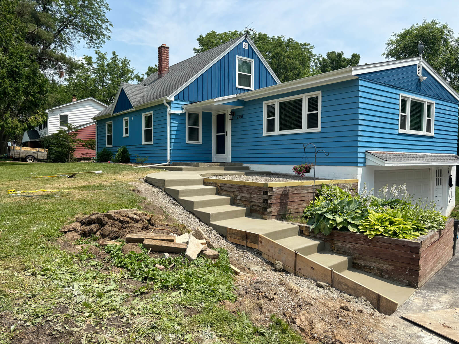 A wide view of the finished concrete steps and surrounding landscaping, providing a clean and safe entryway to a home.
