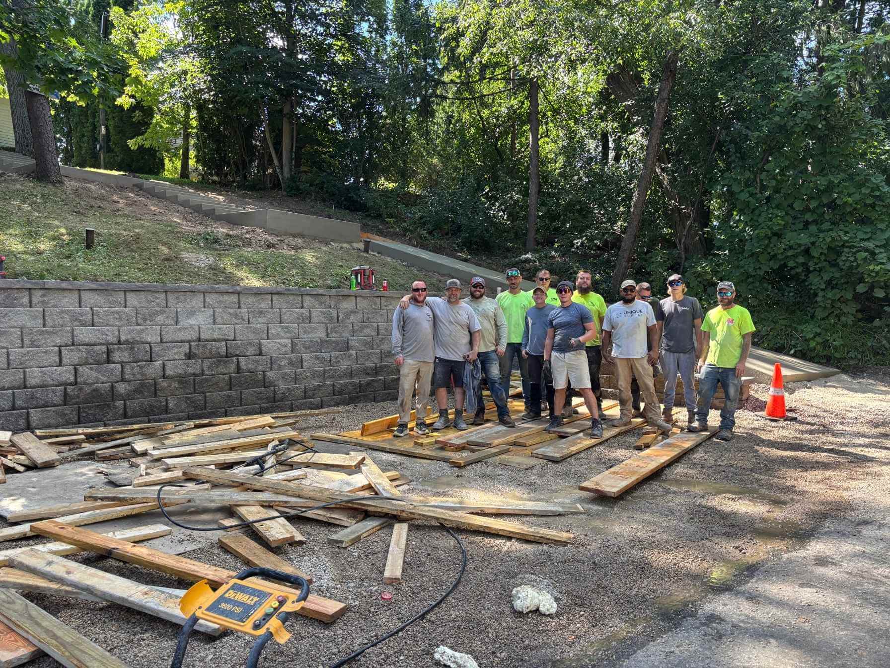 Landscape construction team working on concrete retaining wall and steps in Hartland.
