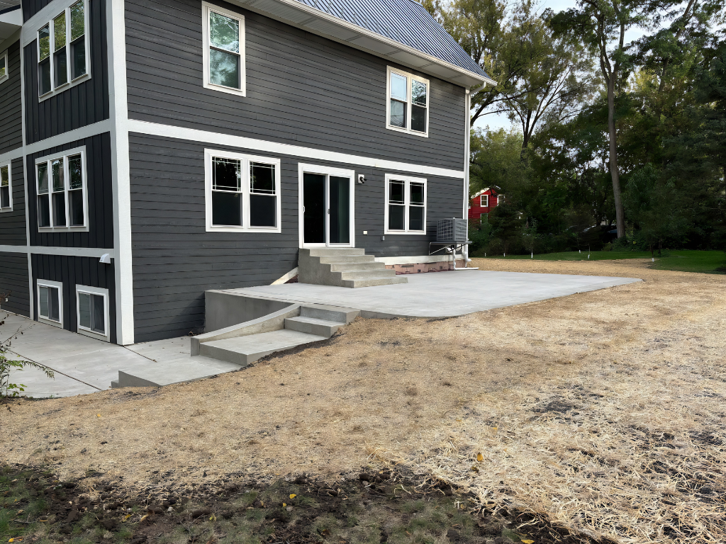  A house featuring a concrete patio and steps leading up to the entrance.